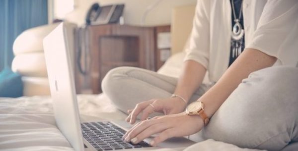 Casual Business Woman Typing On Laptop Whilst In Bed (1)